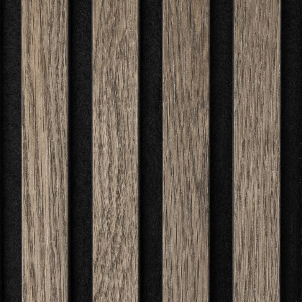 Primer plano de panel acústico WoodUpp: listones verticales de madera clara con vetas pronunciadas y acabado mate, separados por ranuras con fieltro negro absorbente. Se aprecian textura y grano de los listones decorativos WoodUpp, diseñados para control acústico y acabado estético.