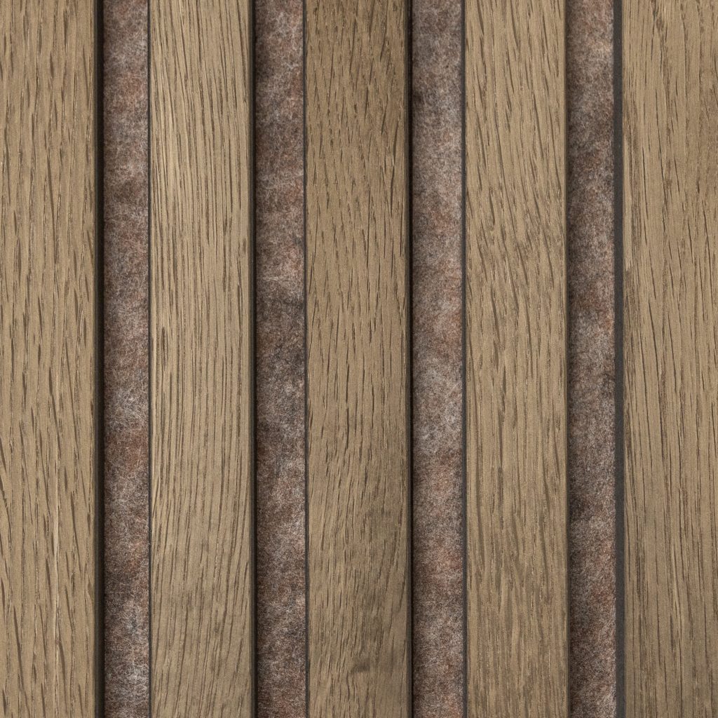 Panel acústico WoodUpp compuesto por lamas verticales de madera clara tipo roble con vetas marcadas, separadas por bandas de fieltro acústico marrón grisáceo. Diseño modular de lamas de madera natural que combina textura cálida y absorción sonora para paredes y techos.