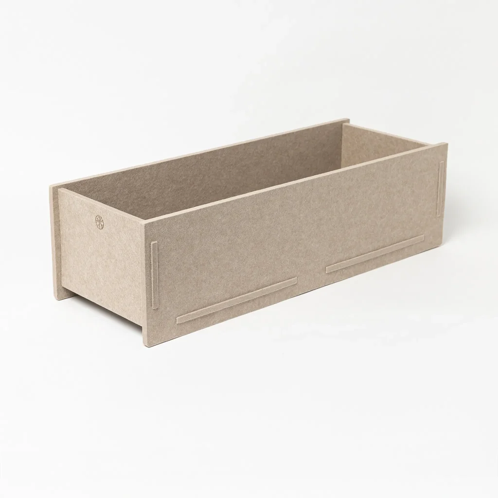 Jardinera rectangular de WoodUpp: caja modular abierta de paneles de fibra de madera beige, ensamblada mediante ranuras y pestañas. Diseño bajo, sin plantas ni tierra, con acabados lisos y bordes rectos, minimalista, apta como macetero organizador para interiores o balcones.